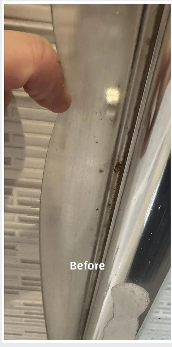 A shower screen edge before a True Grit deep clean, with limescale and grime built up