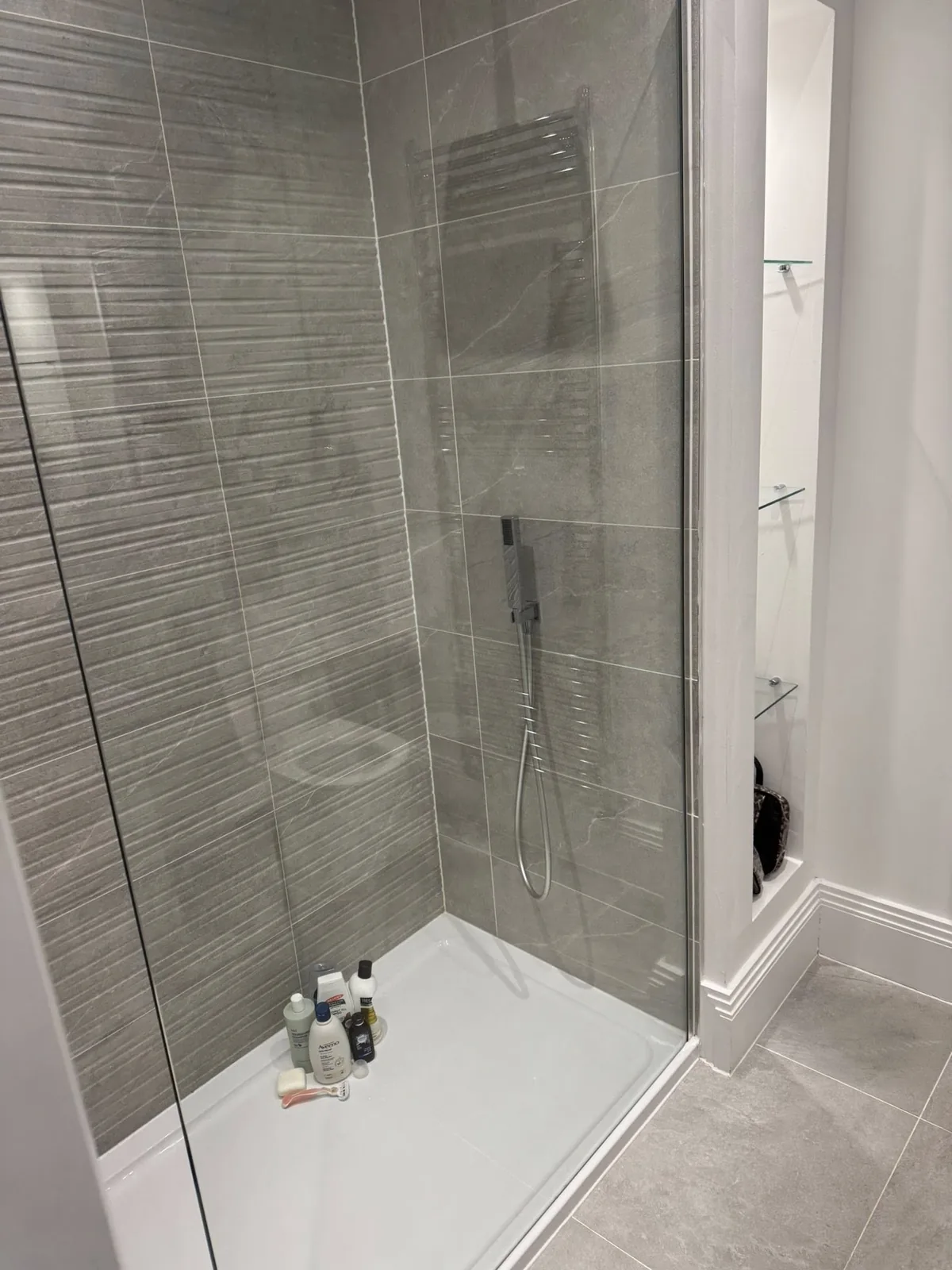 A grey-tiled bathroom and shower after a deep clean in Richmond